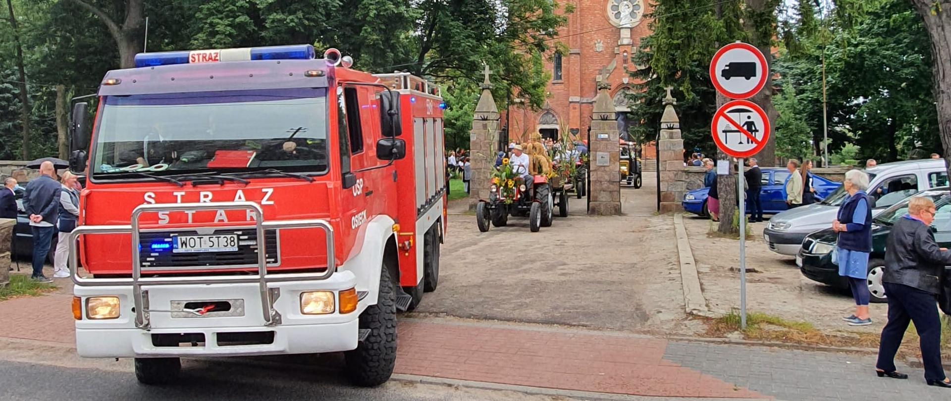 Na zdjęci widoczny wóz bojowy OSP Osieck przy kościele. 