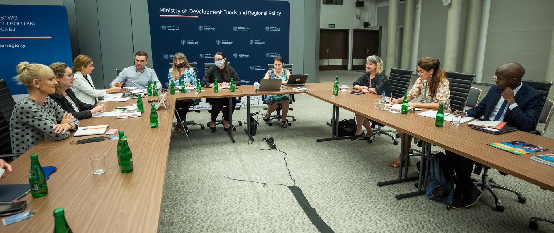 uczestnicy spotkania w Ministerstwie Funduszy i Polityki Regionalnej z misją UN-Habitat siedzą wokół stołu