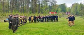 Zdjęcie przedstawia odprawę uczestników ćwiczeń z kierownictwem KP PSP w Pruszczu Gdańskim na śródleśnej polanie