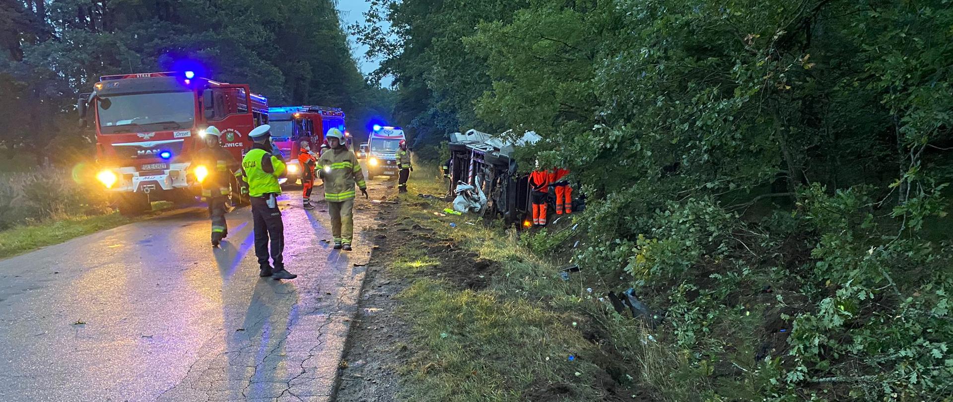 Na zdjęciu widoczny funkcjonariusz KP Policji w Lęborku, ratownicy JOP, ratownicy PRM, pojazdy pożarnicze, karetka pogotowia oraz pojazd dostawczy biorący udział w zdarzeniu drogowym w dniu 21 września br. w miejscowości Oskowo.