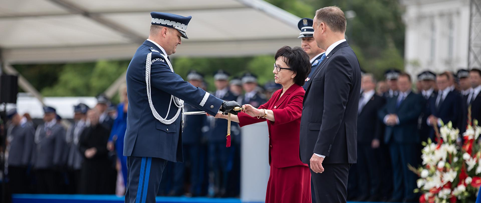 Minister Elżbieta Witek wręczająca pamiątkową szablę generalską oficerowi Policji.