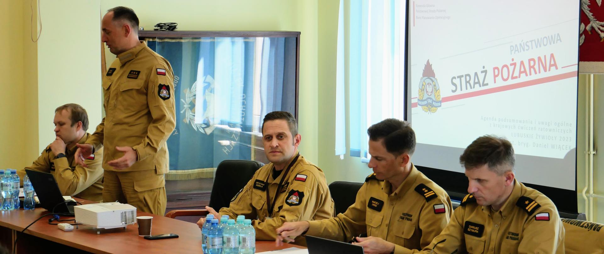 Podsumowanie ćwiczeń "Lubuskie Żywioły 2023" - stół przy którym siedzą prowadzący odprawę