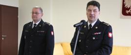 Komendant Centralnej Szkoły PSP przemawiający do mikrofonu podczas spotkania wielkanocnego. Po lewej nowy Zastępca Komendanta CS PSP