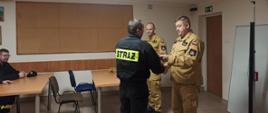 W sali dydaktycznej budynku Komendy Powiatowej Państwowej Straży Pożarnej w Rypinie, dowódca Jednostki ratowniczo-gaśniczej brygadier Dariusz Łęgosz oraz Jego zastępca młodszy brygadier Cezary Nowiński wręczają zaświadczenia potwierdzające zaliczenie kursu podstawowego.