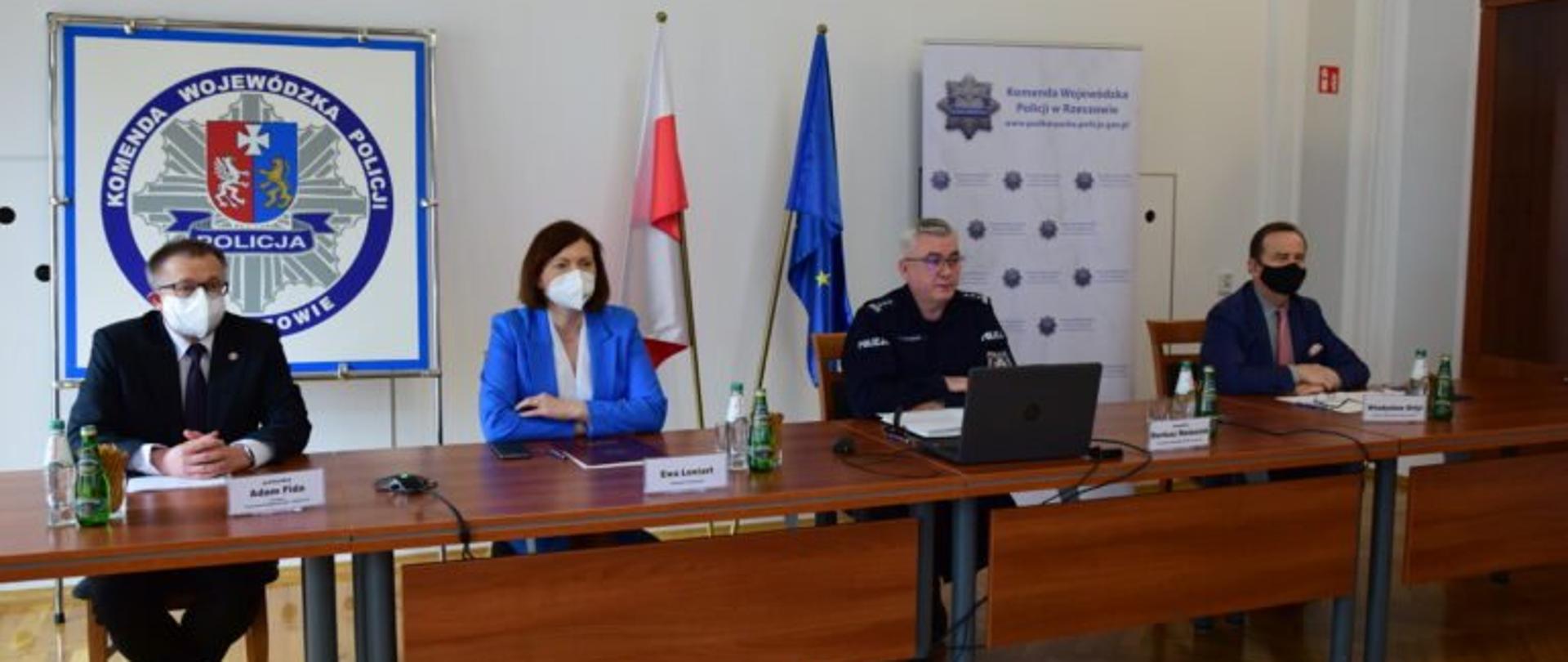 Wojewoda Ewa Leniart przy stole prezydialnym podczas narady rocznej podkarpackiej Policji obok innych uczestników posiedzenia