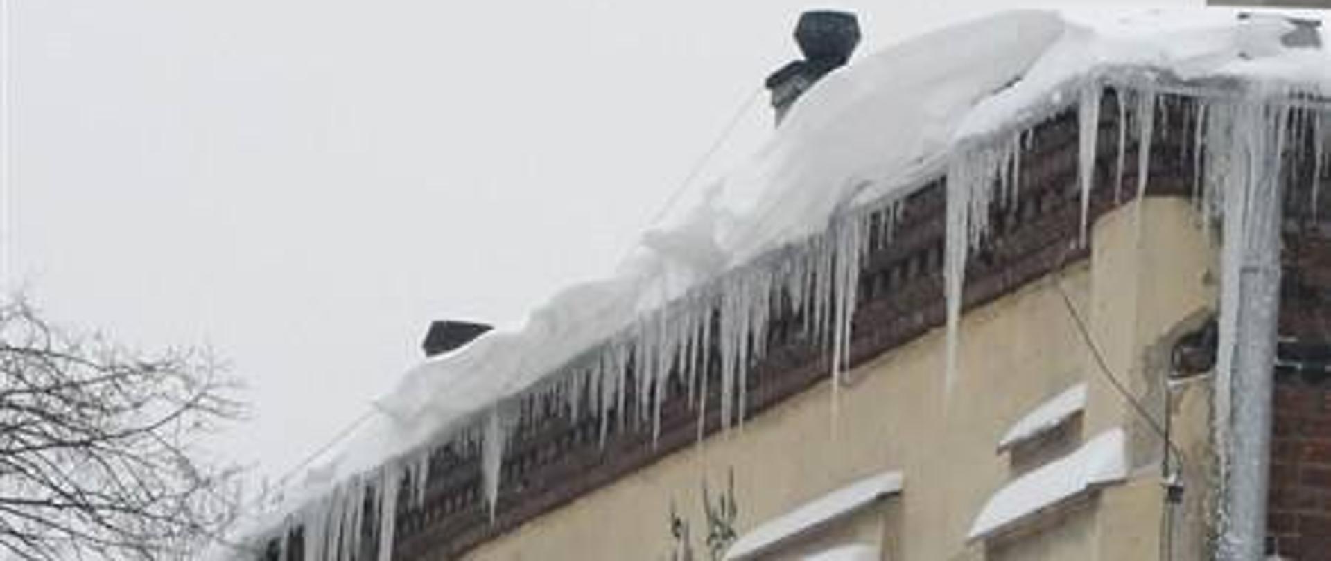 Nawisy śnieżne i lodowe na dachu budynku
