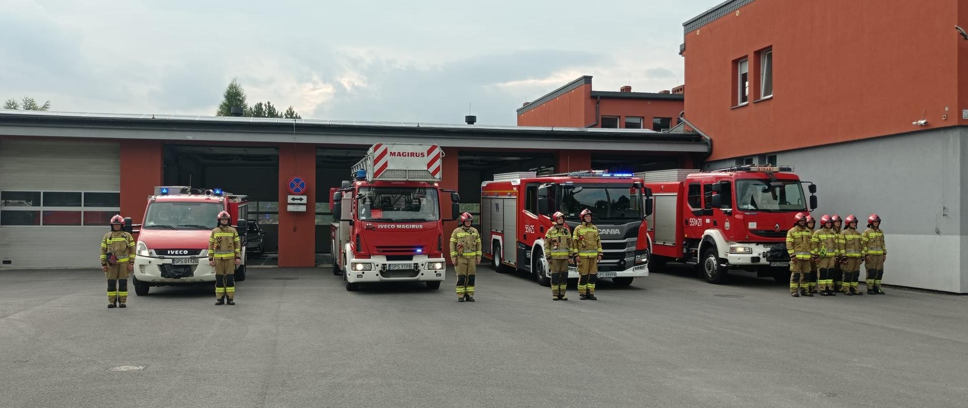 Zdjęcie przedstawia strażaków i pojazdy pożarnicze
