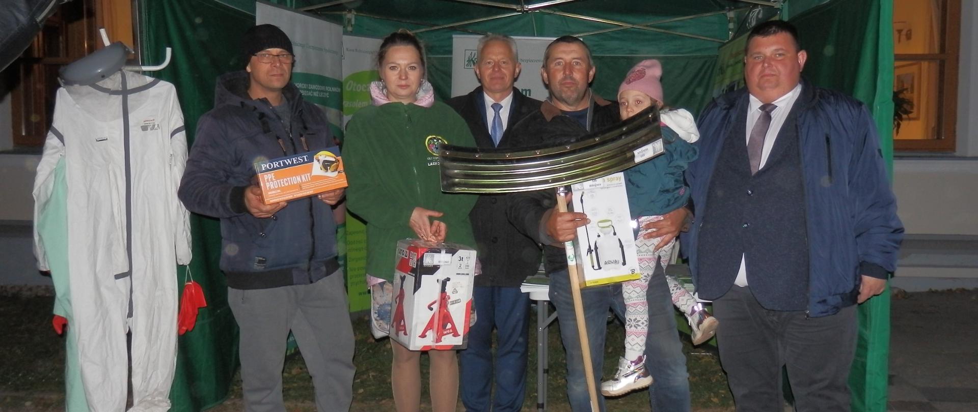 czterech mężczyzn, jedna kobieta i dziecko przed zielonym namiotem KRUS