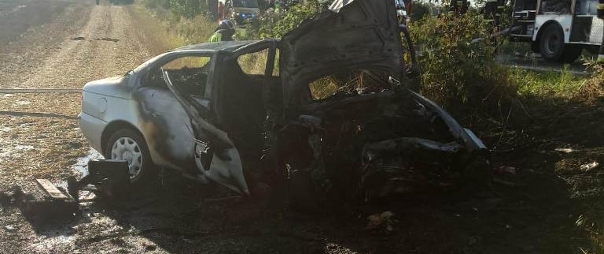 Samochód osobowy który uderzył w drzewo a następnie uległ zapaleniu. 