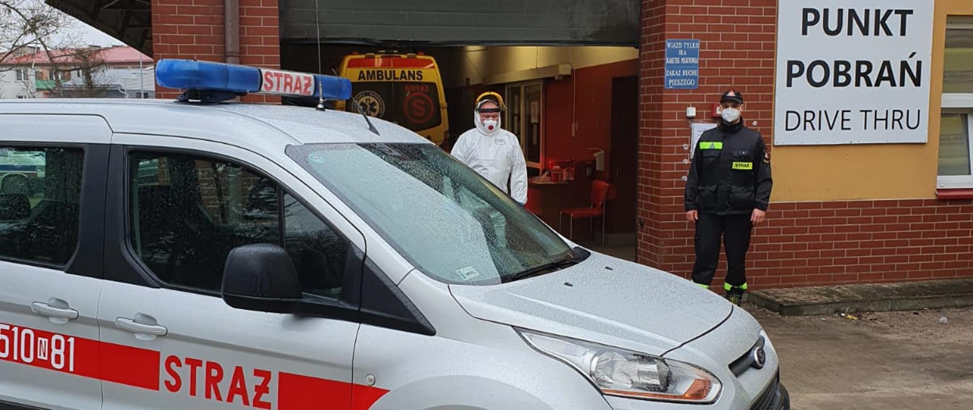 Strażak przed punktem wymazowym oraz samochodu SLkw