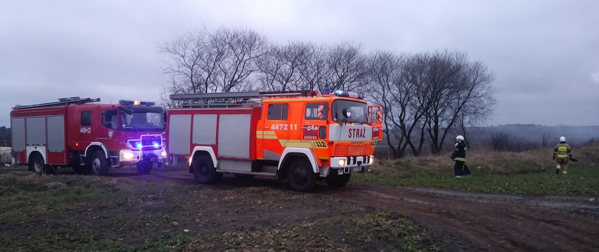 na zdjęciu widać pojazd gaśniczy oraz strażaków gaszących pożar nieużytków