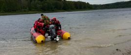 Uczestnicy szkolenia znajdujący się na łodzi ratowniczej na akwenie wodnym.