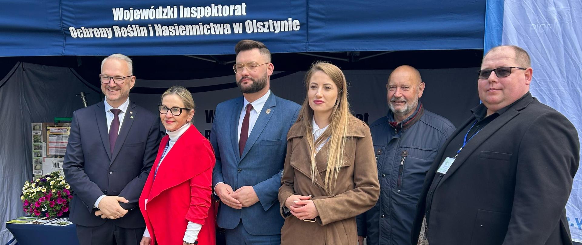 Grupa osób pozuje do zdjęcia na tle stoiska WIORiN, Wojewoda Warmińsko-Mazurski Radosław Król, Wojewódzka Inspektor Katarzyna Dębowska, Dyrektor WMODR Mateusz Cygan wraz z kierowniczką PZD w olecku, kierownik DNF Artur Borkowski, Z-ca Dyrektora WMODR Paweł Mostowicz