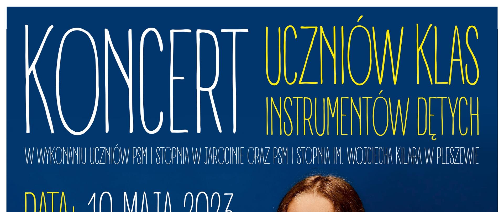 Granatowe tło. Od góry duży napis "Koncert uczniów klas instrumentów dętych PSM I stopnia Jarocinie oraz PSM I stopnia im. Wojciecha Kilara w Pleszewie. Data: 10 maja 2023 Godzina: 17:00" Na środku dziewczyna z brązowymi, rozpieszczonymi włosami, ubrana w niebieską sukienkę w białe groszki, trzymająca w ustach czarny klarnet. Na dole od lewej stronie napis "Kamienica Kultury ul. Rynek 17 w Jarocinie. Więcej informacji na: www.psmjarocin.pl Zapraszamy!" Na dole plakatu na białym tle napis " Zapraszamy również na nasze profile w mediach społecznościowych Facebook oraz YouTube"