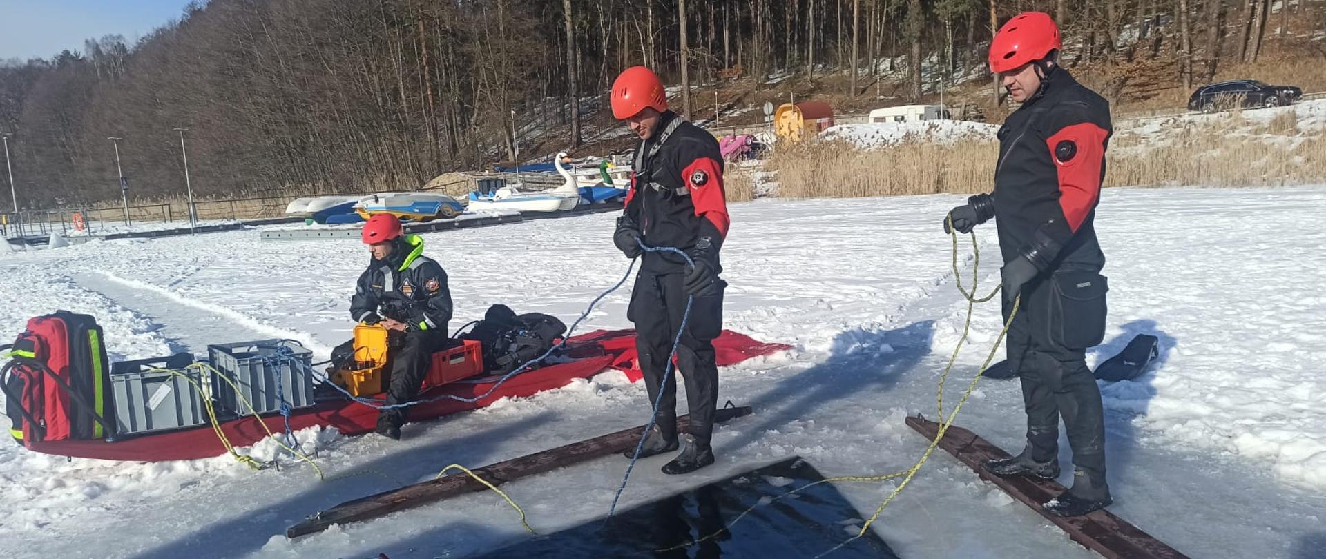 Na zdjęciu widnieją strażacy w trakcie szkolenia z nurkowania podlodowego. 