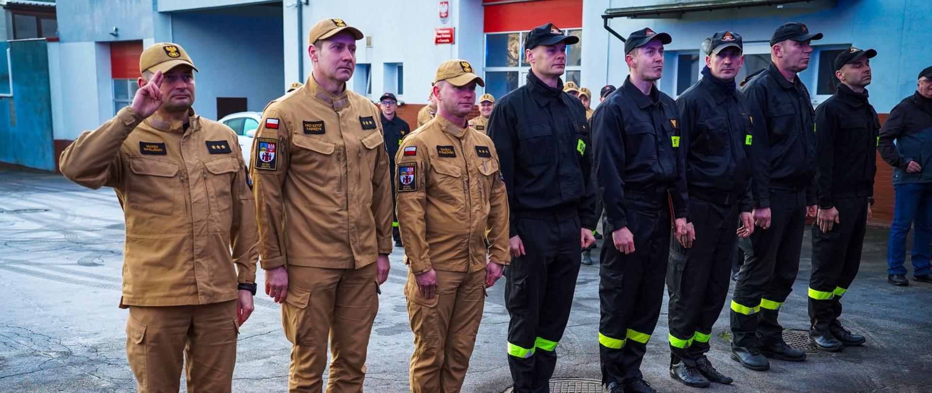 Strażacy stoją podczas zmiany służby.