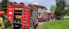 Samochody pożarnicze ustawione na drodze dojazdowej podczas działań gaśniczych