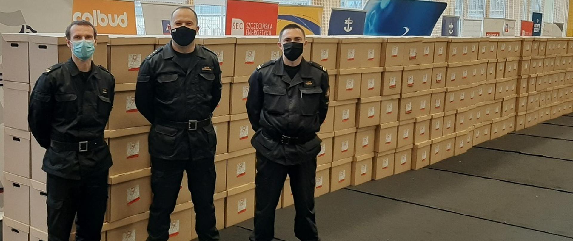 Trzech strażaków przy dużej ilości paczek