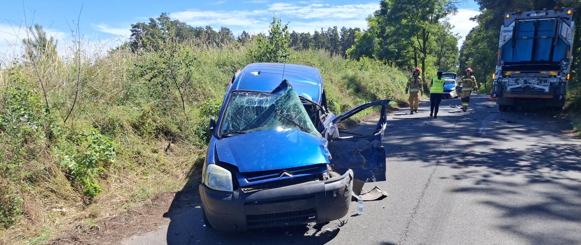 auto osobowe rozbite, w tle samochód ciężarowy