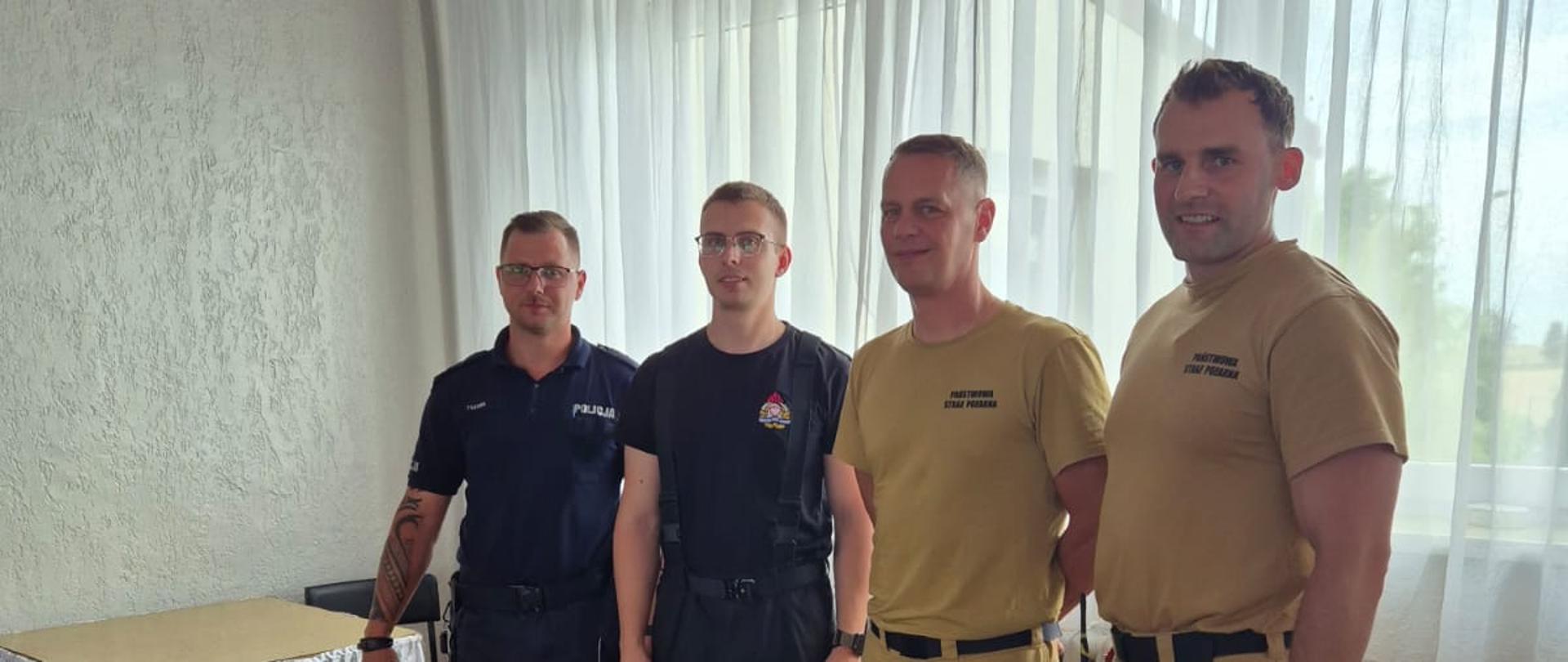 Funkcjonariusz PSP i Policji przy stoisku z ulotkami
