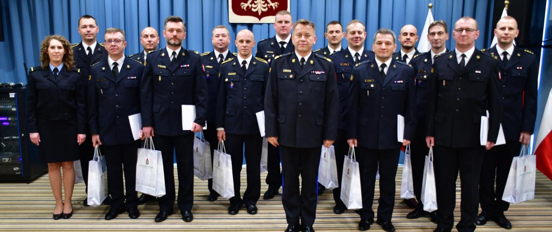 Wyróżnienie oficerów prasowych z terenu województwa mazowieckiego - na zdjęciu stoją w mundurach wyjściowych wyróżnieni wraz z Komendantem Wojewódzkim.