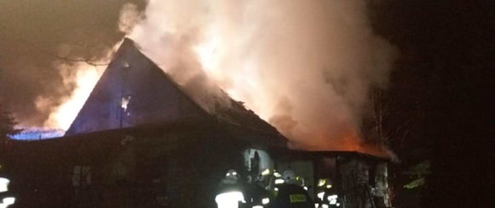 Na zdjęciu widać budynek objęty ogniem oraz strażaków 