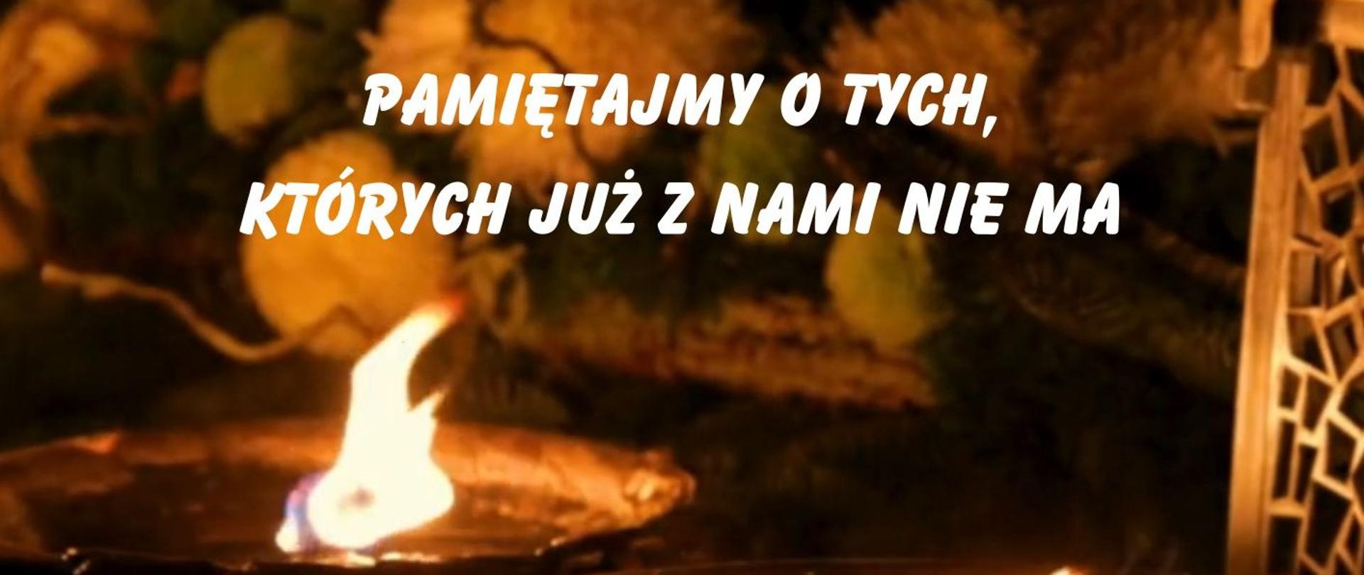 Pamiętajmy o tych, których już z nami nie ma - w tle dwa płonące znicze 