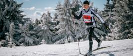 Zdjęcie przedstawia mężczyznę biegnącego na nartach biegowych.