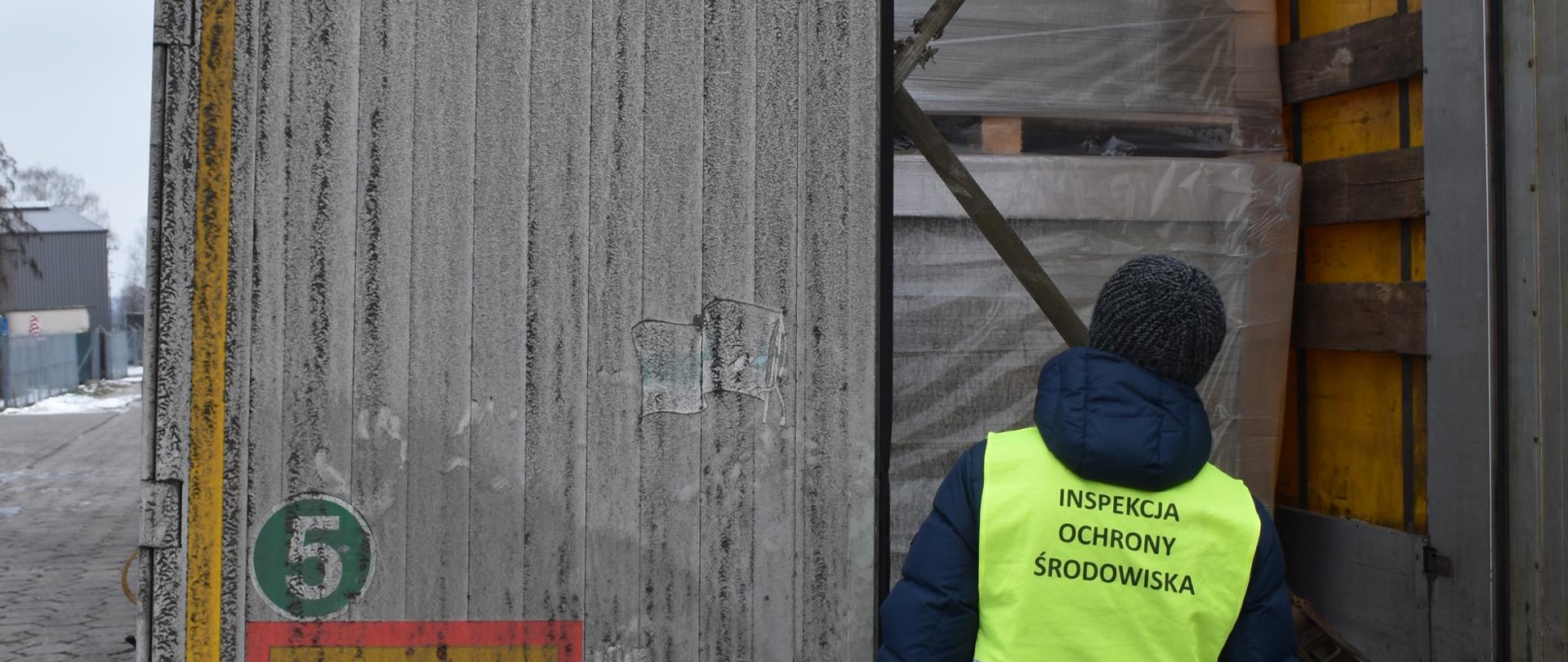 Inspektor Inspekcji Ochrony Środowiska w Warszawie kontroluje pojazd ciężarowy.