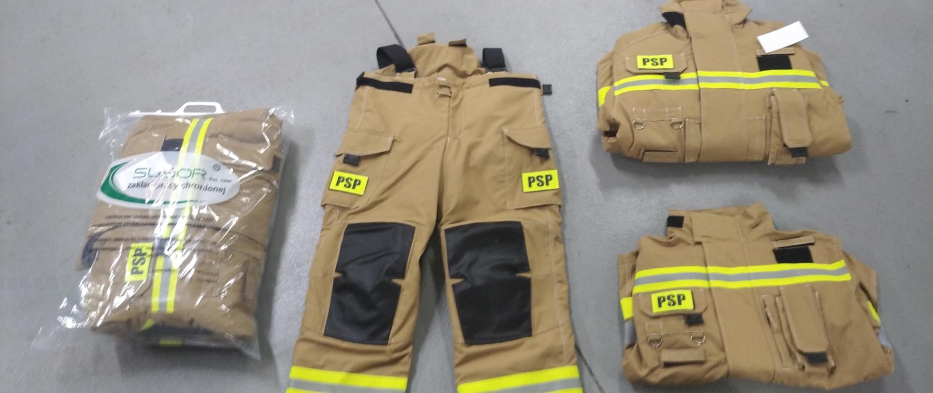 Na podłodze leży jeden komplet żółtych ubrań specjalnych, a obok rozłożony komplet ubrań specjalnych .