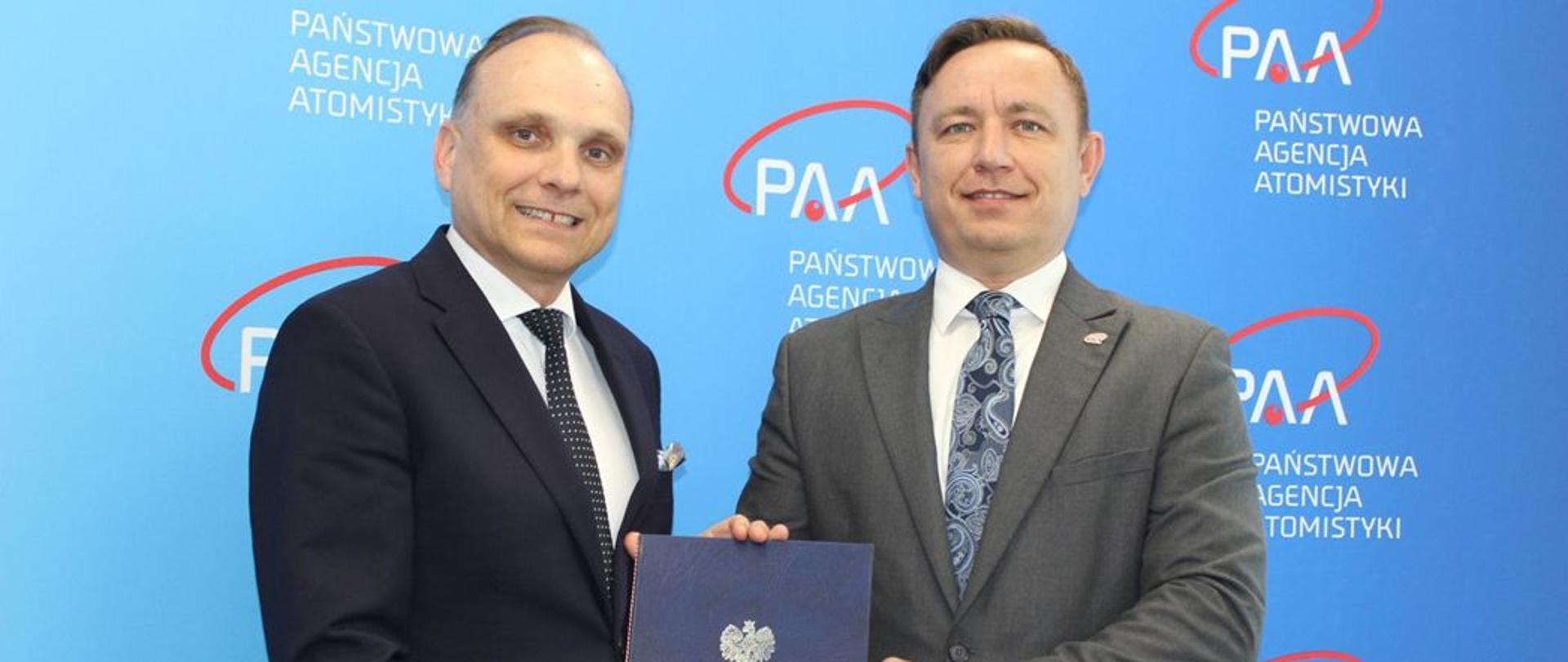 President of PAA Andrzej Głowacki and Paweł Pichniarczyk, Director of Łukasiewicz – Institute of Ceramics and Building Materials are holding a folder with the decision to grant PAA authorization