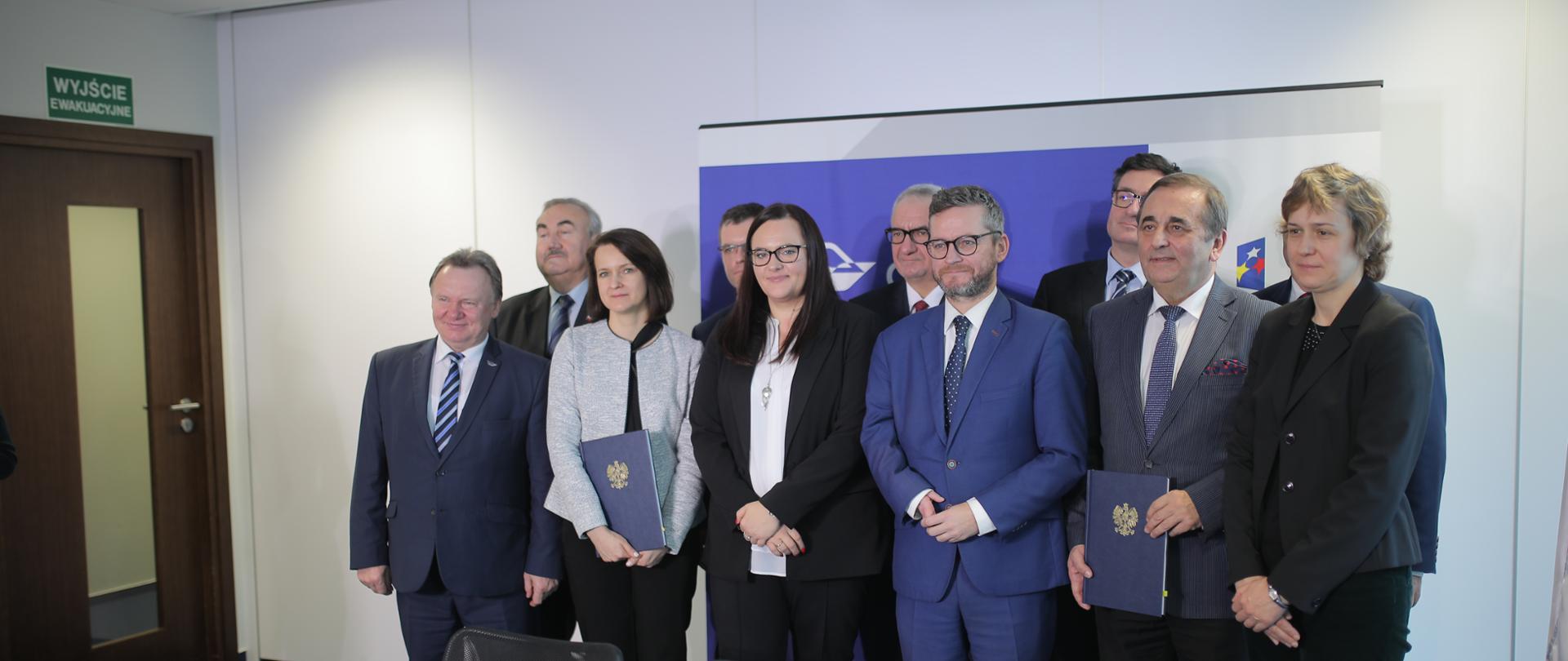 Zdjęcie grupowe. Na zdjęciu 11 osób, wśród nich m. in. Małgorzata Jarosińska-Jedynak, prezes PKP PLK Ireneusz Merchel, wiceminister Grzegorz Witkowski, dyrektor CUPT Joanna Lech. 