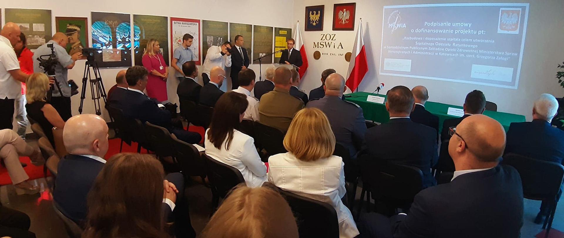 Wiceminister Krzysztof Kozłowski przemawia. Zdjęcie z tyłu sali. 