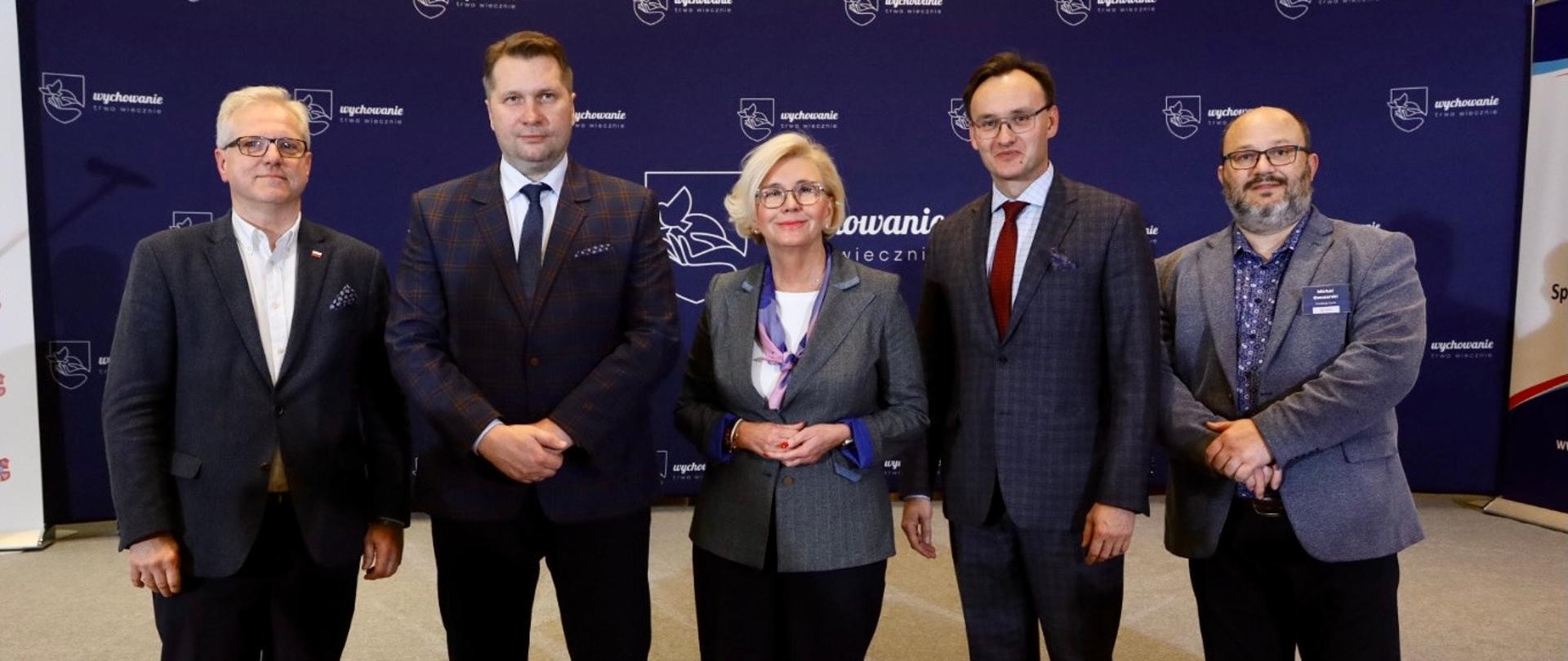 II Ogólnopolski Kongres „Wychowanie trwa wiecznie” z udziałem kierownictwa MEiN, minister Przemysław Czarnek i wiceminister Marzena Machałek stoją w towarzystwie uczestników konferencji.