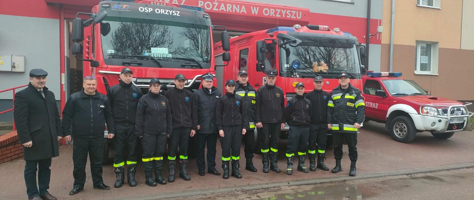 Strażacy stojący przed remizą