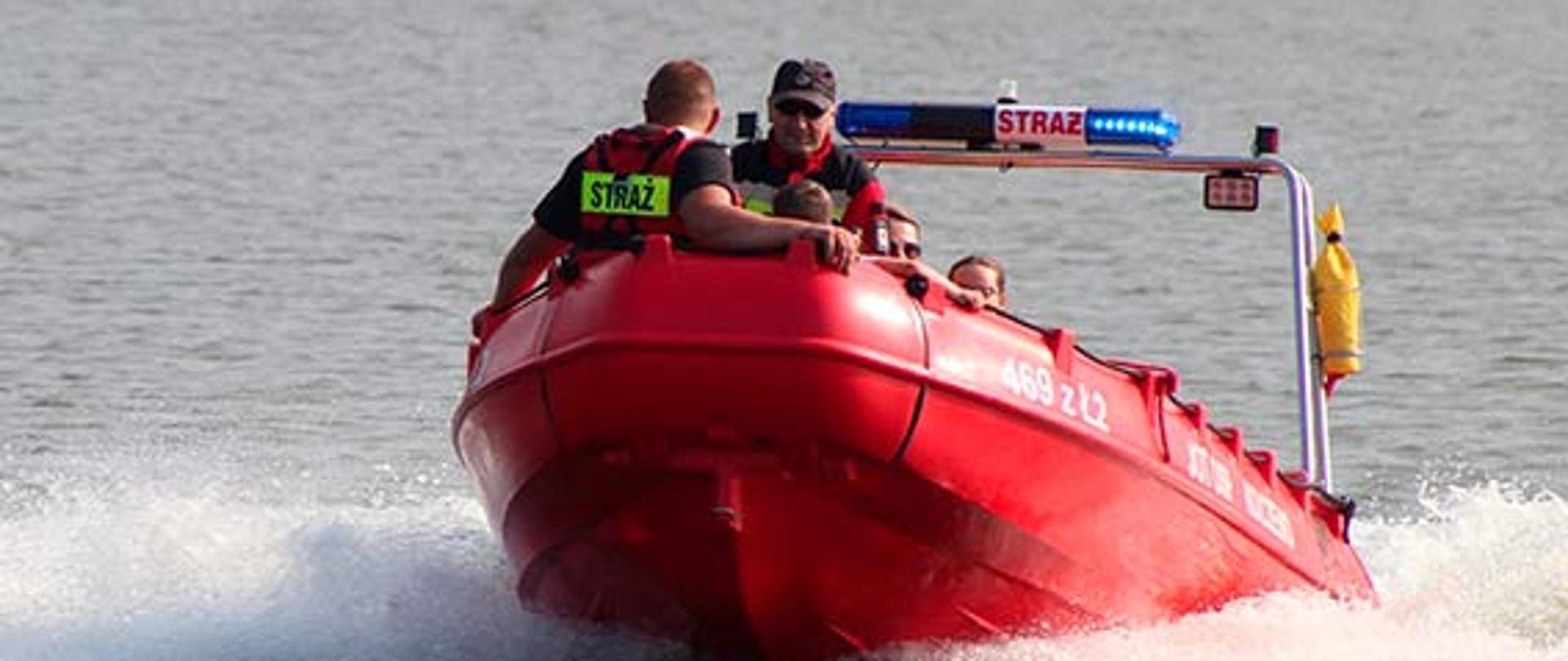 Zdjęcie przedstawia lódź straży pożarnej na wodzie podczas działań ratowniczych.