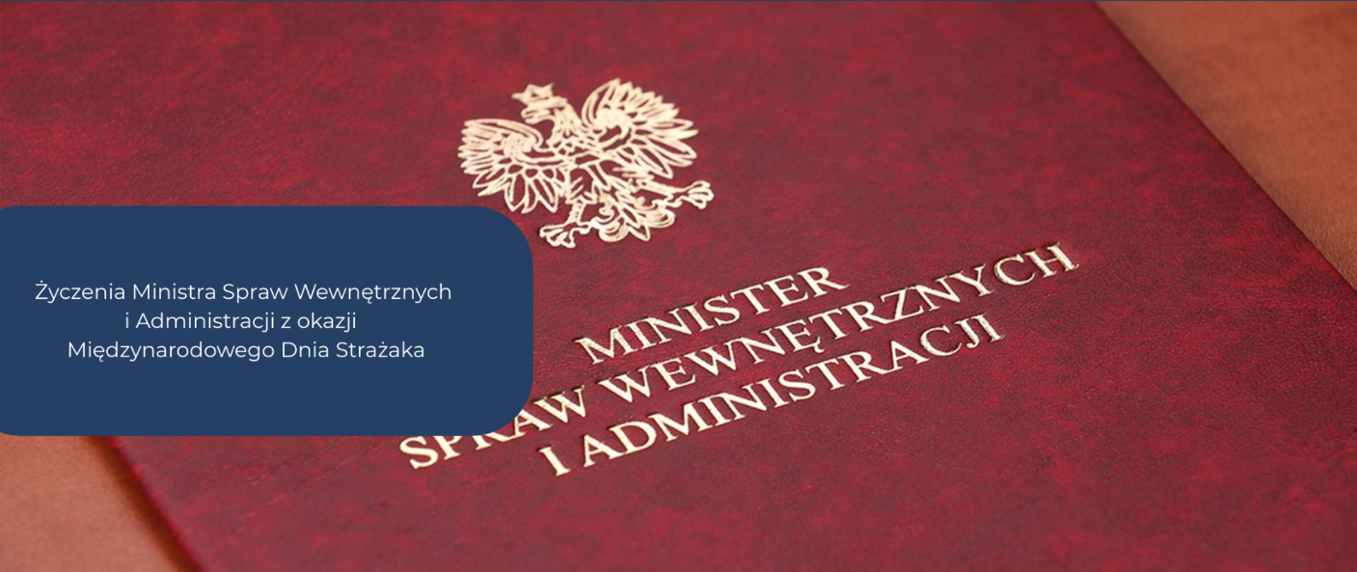 Teczka ministerialna w kolorze czerwonym, ze złotym orłem - godłem.