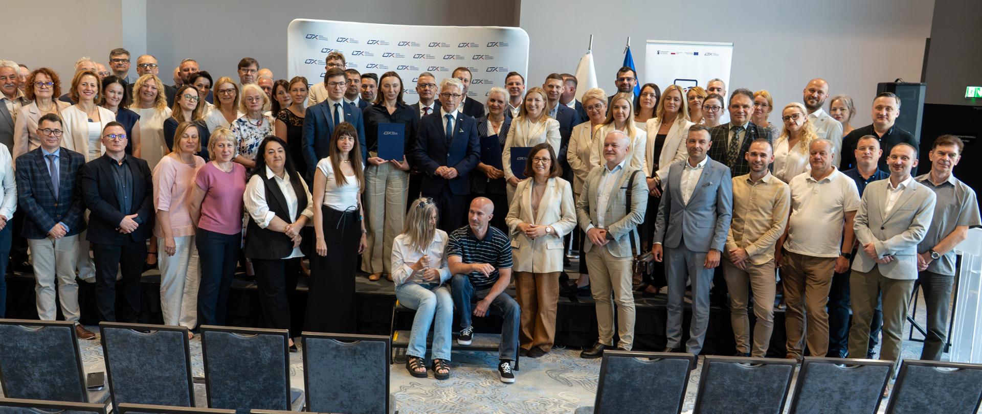 Grupa ludzi pozujących do zdjęcia.