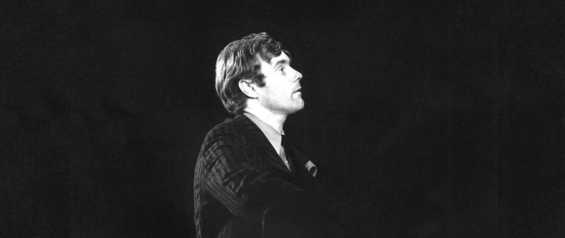 Czarno-białe zdjęcie Krzysztofa Komedy przy fortepianie