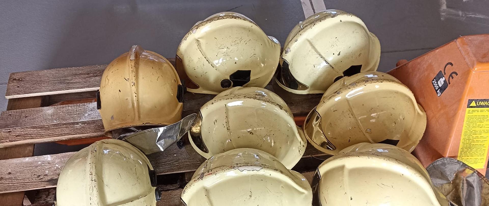 Zdjęcie przedstawia osiem hełmów strażackich