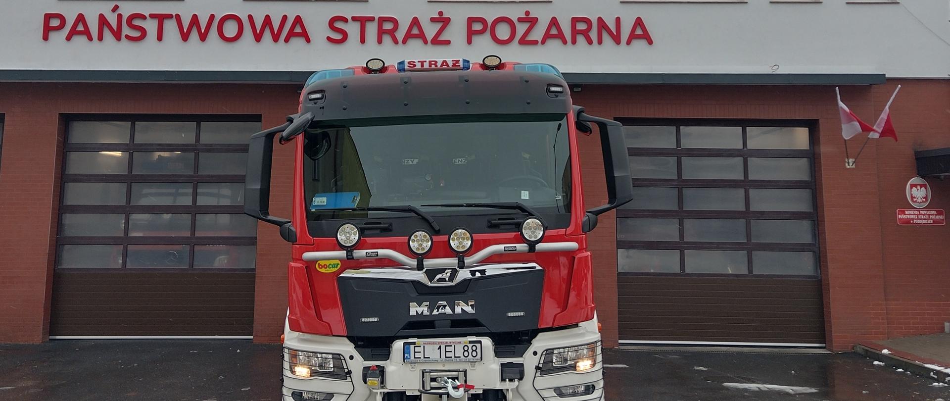 Nowy pojazd marki Man stojący przed garażami budynku Komendy Powiatowej PSP w Poddębicach 