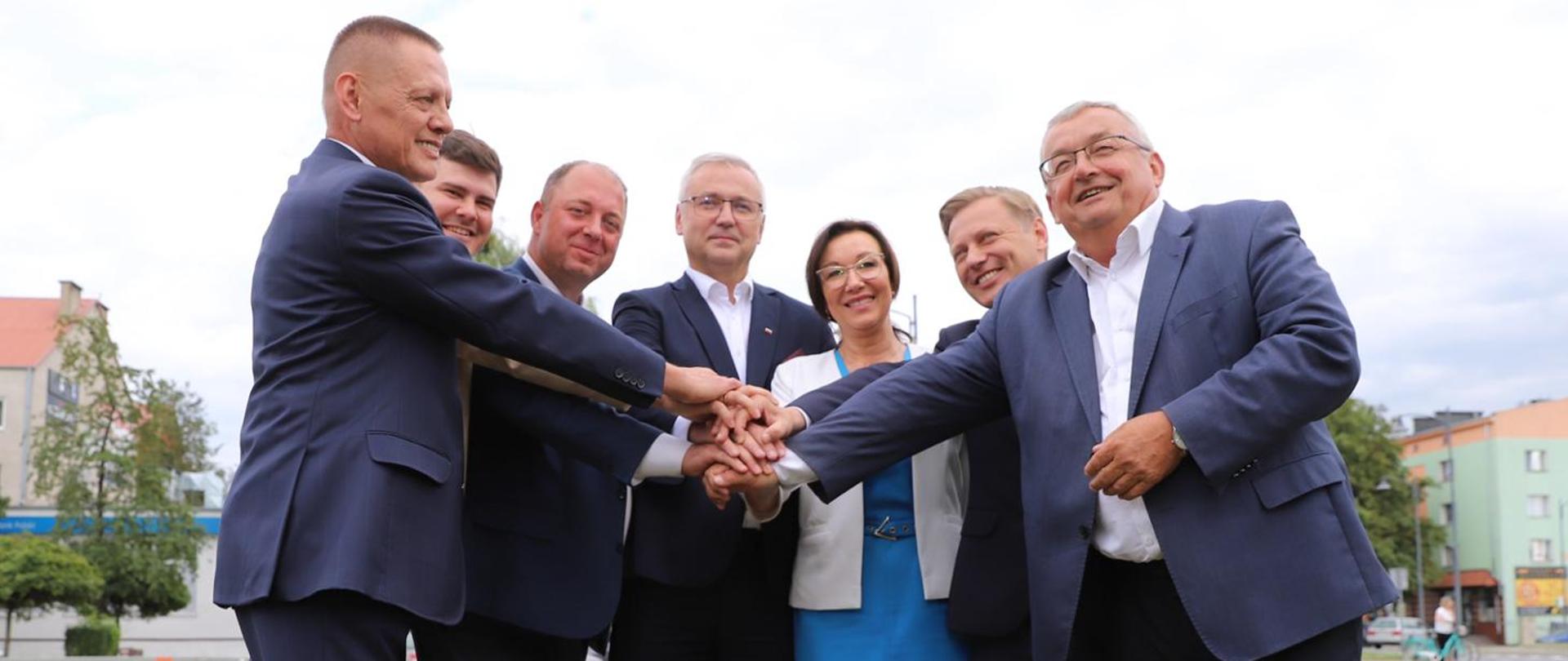 Minister infrastruktury Andrzej Adamczyk w trakcie konferencji prasowej w Piszu w towarzystwie parlamentarzystów, samorządowców i dyrektora oddziału GDDKiA w Olsztynie, Mirosława Nicewicza