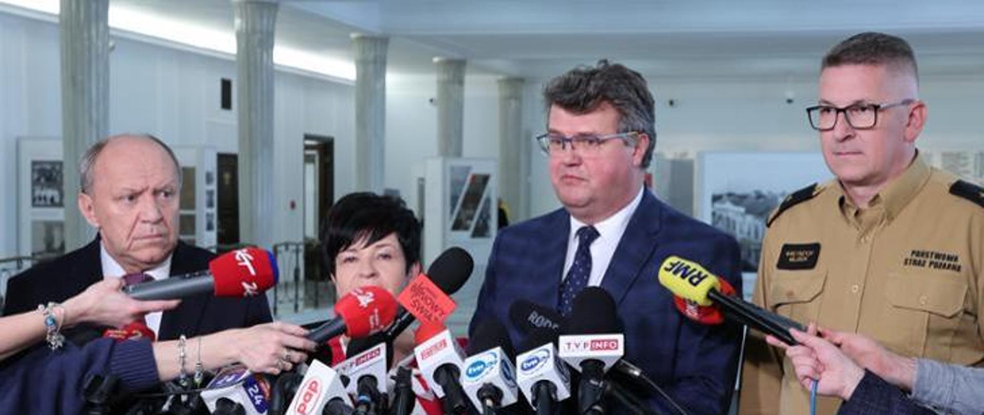 Na zdjęciu widać ministra Macieja Wąsika z zastępcą Komendanta Głównego PSP nadbryg. Krzysztofem Hejdukiem oraz posłami podczas konferencji prasowej 
