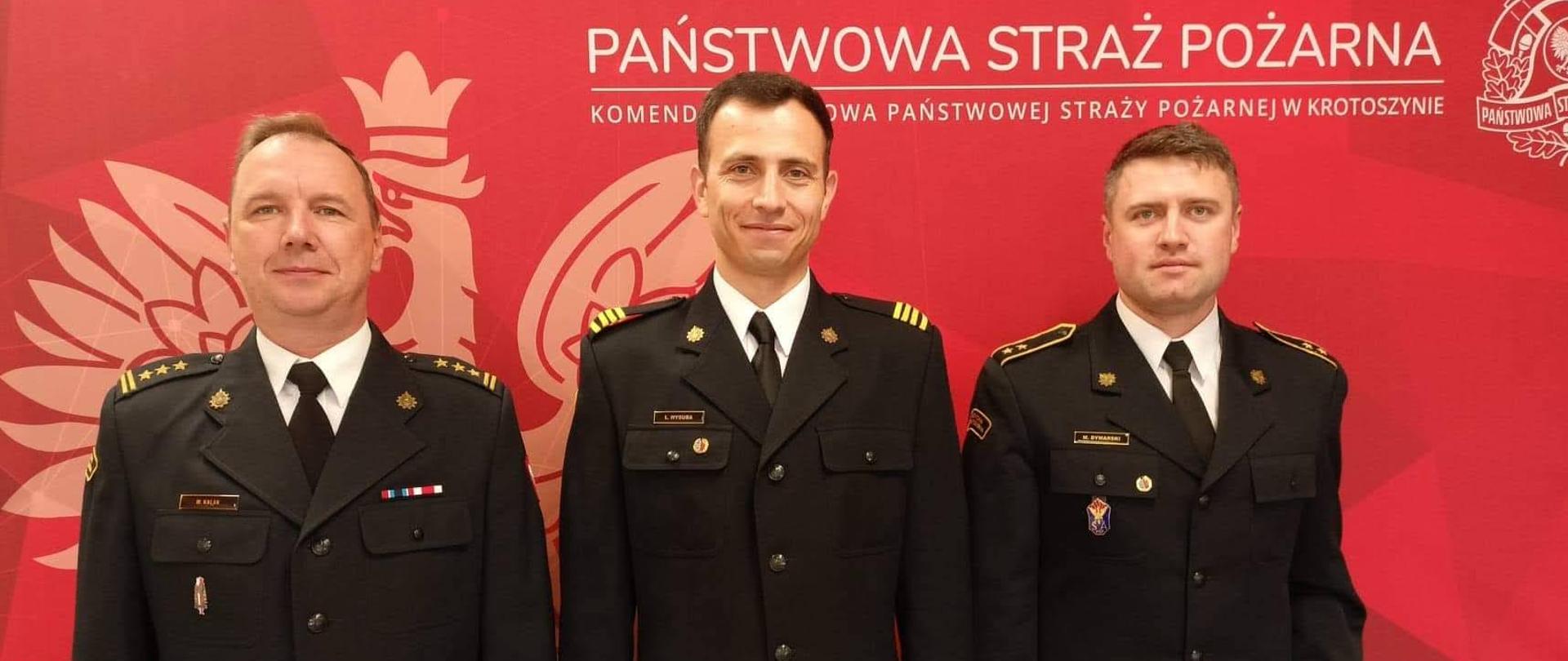 Pełniący obowiązki Komendanta Powiatowego PSP w Krotoszynie st. bryg. Marek Kalak spotkał się ze strażakami, którzy ukończyli studia podyplomowe w Szkole Głównej Służby Pożarniczej. Na zdjęciu komendant wraz z wyróżnionymi strażakami w umundurowaniu wyjściowym. Uroczystość ma miejsce na świetlicy komendy powiatowej.