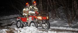 Na zdjęciu w porze nocnej. Na zdjęciu widoczni dwaj strażacy jadący quadem. Warunki zimowe, śnieg, strażacy w działaniach podczas gaszenia .