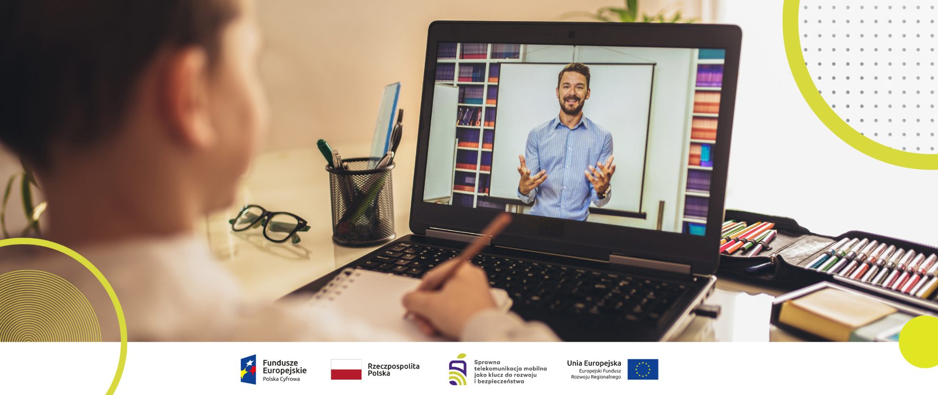 Zdjęcie przedstawia chłopca w wieku szkolnym siedzącego przed komputerem, na którym widać nauczyciela.