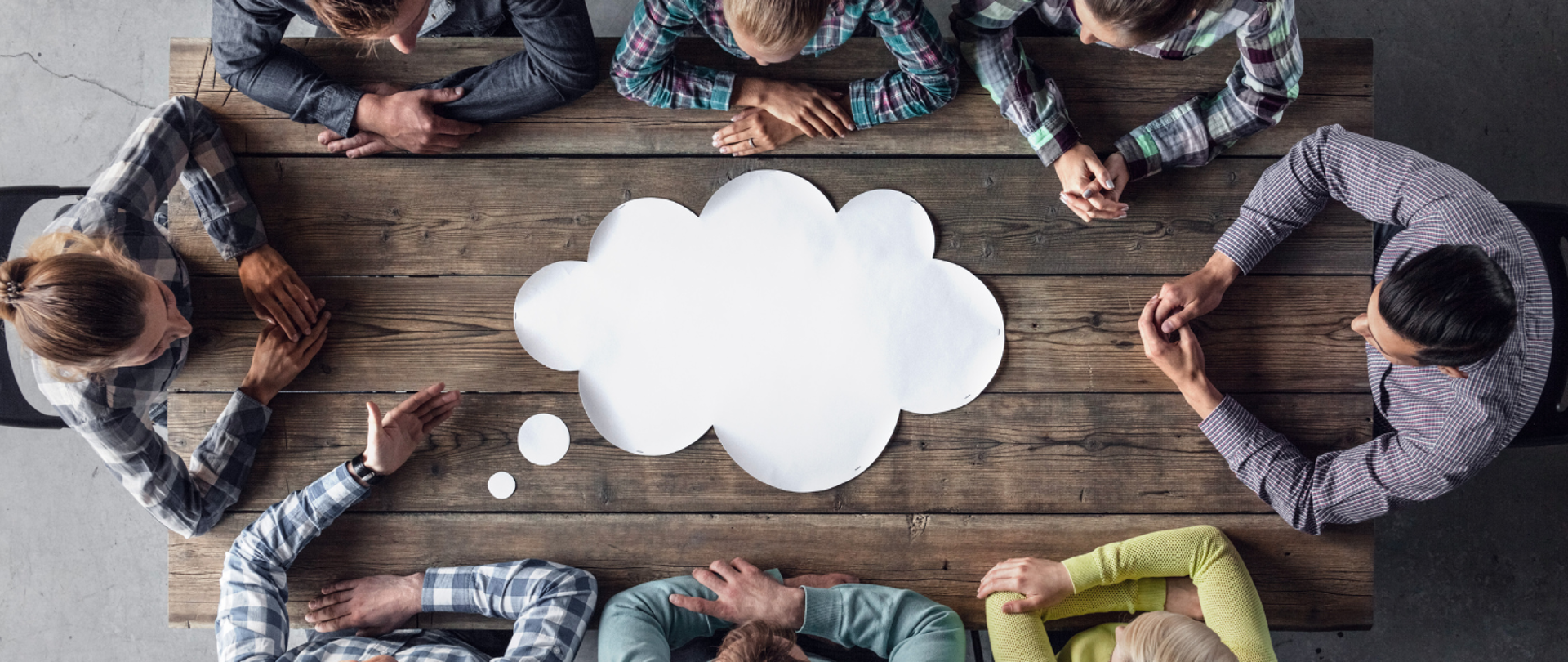 na zdjęciu widoczna jest grupa osób siedzących przy stole i dyskutujących. 