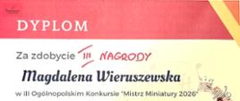 Zdjęcie przedstawia dyplom zdobyty na III Ogólnopolskim Konkursie "Mistrz Miniatury 2026". U góry i na dole czerwone tło. Po środku informacje dotyczące laureata oraz graficzny rysunek przedstawiający skrzypce, nuty i metronom.