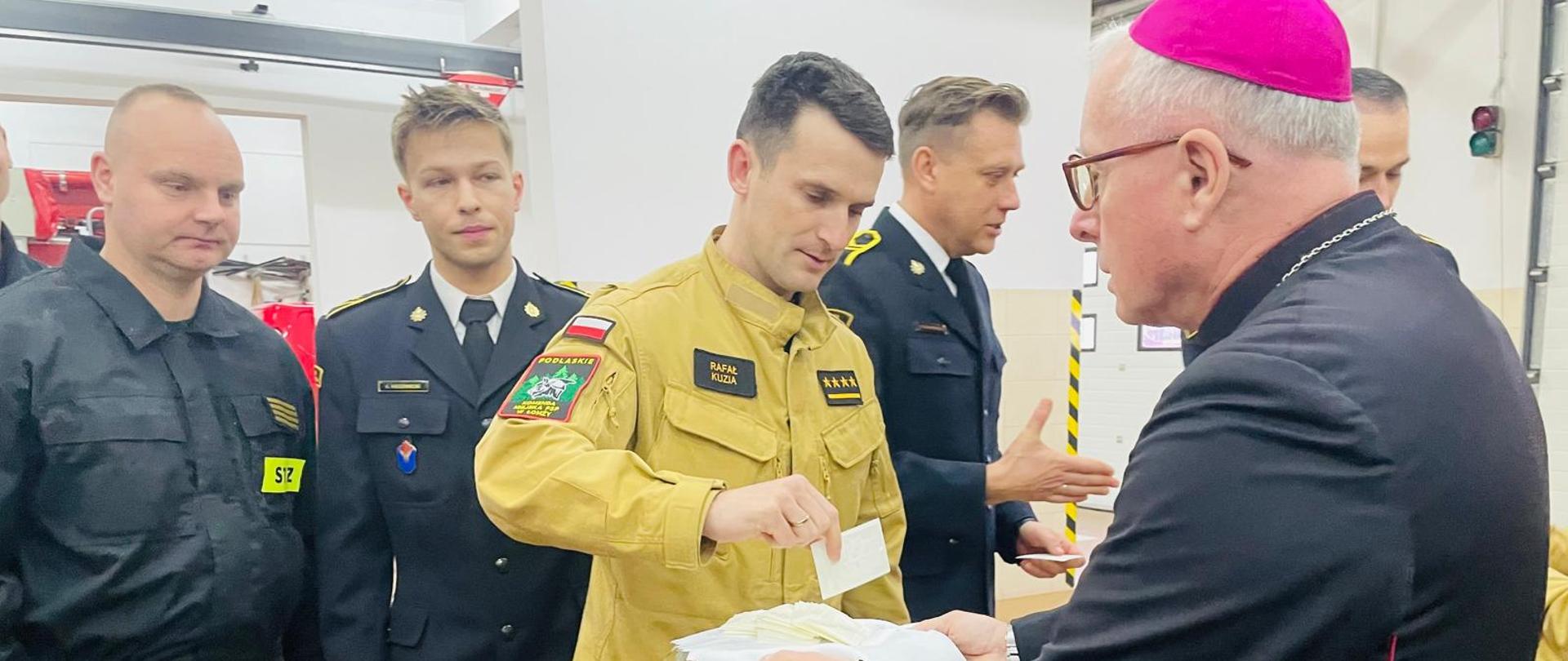 Biskup Janusz Stepnowski rozdaje poświęcone opłatki