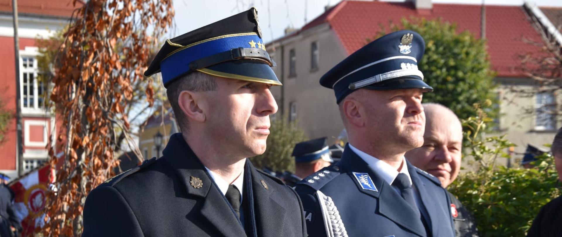 Komendant Powiatowy PSP oraz Naczelnik Policji stoją podczas uroczystości na rynku.